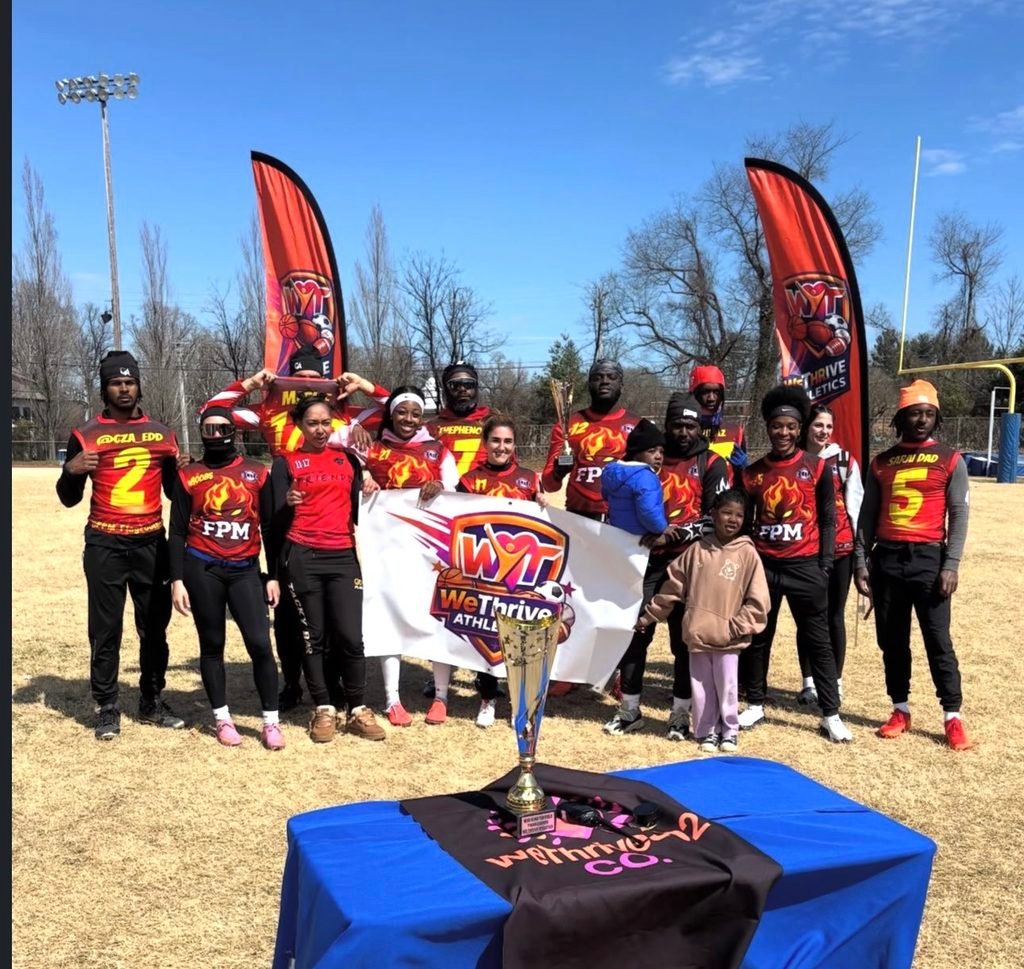 WeThrive Athletics team members celebrating together on the field.