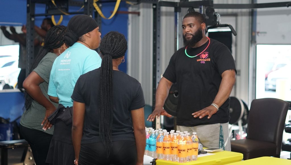 A WeThrive leader speaks with community partners at a wellness event.